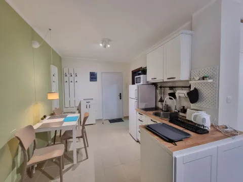 Kitchen with a dining area and white cabinetry. - image 3