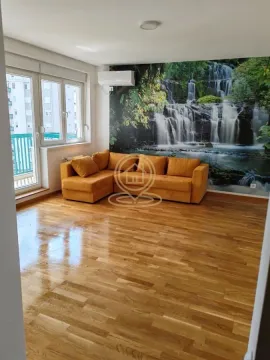 Dnevna soba sa ugaonom garniturom, drvenim parketom i tapetom sa motivom vodopada. - image 3