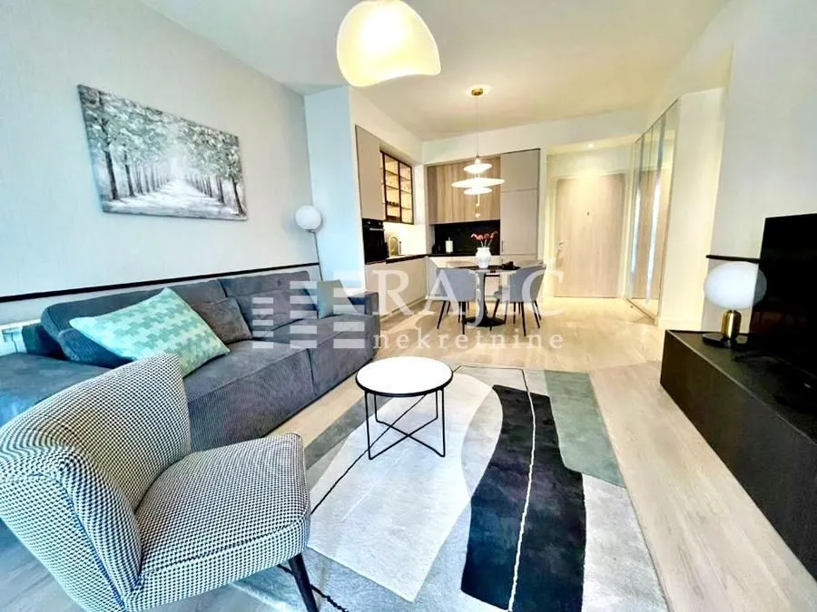 Modern living room with a sofa and dining area in the background.