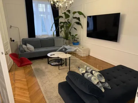 Dnevna soba sa garniturom, televizorom i drvenim podom. - image 2