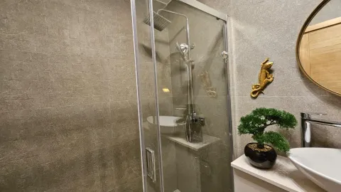 Moderno kupatilo sa staklenom tuš kabinom i ukrasnim detaljima. - image 13