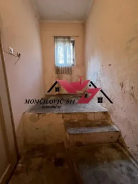 Prazna prostorija u izvornom stanju sa stepenicama i prozorom. - image 4