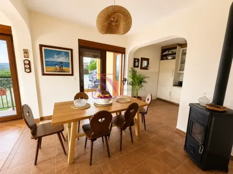 Dining area with a wooden table and a wood-burning stove. - image 7