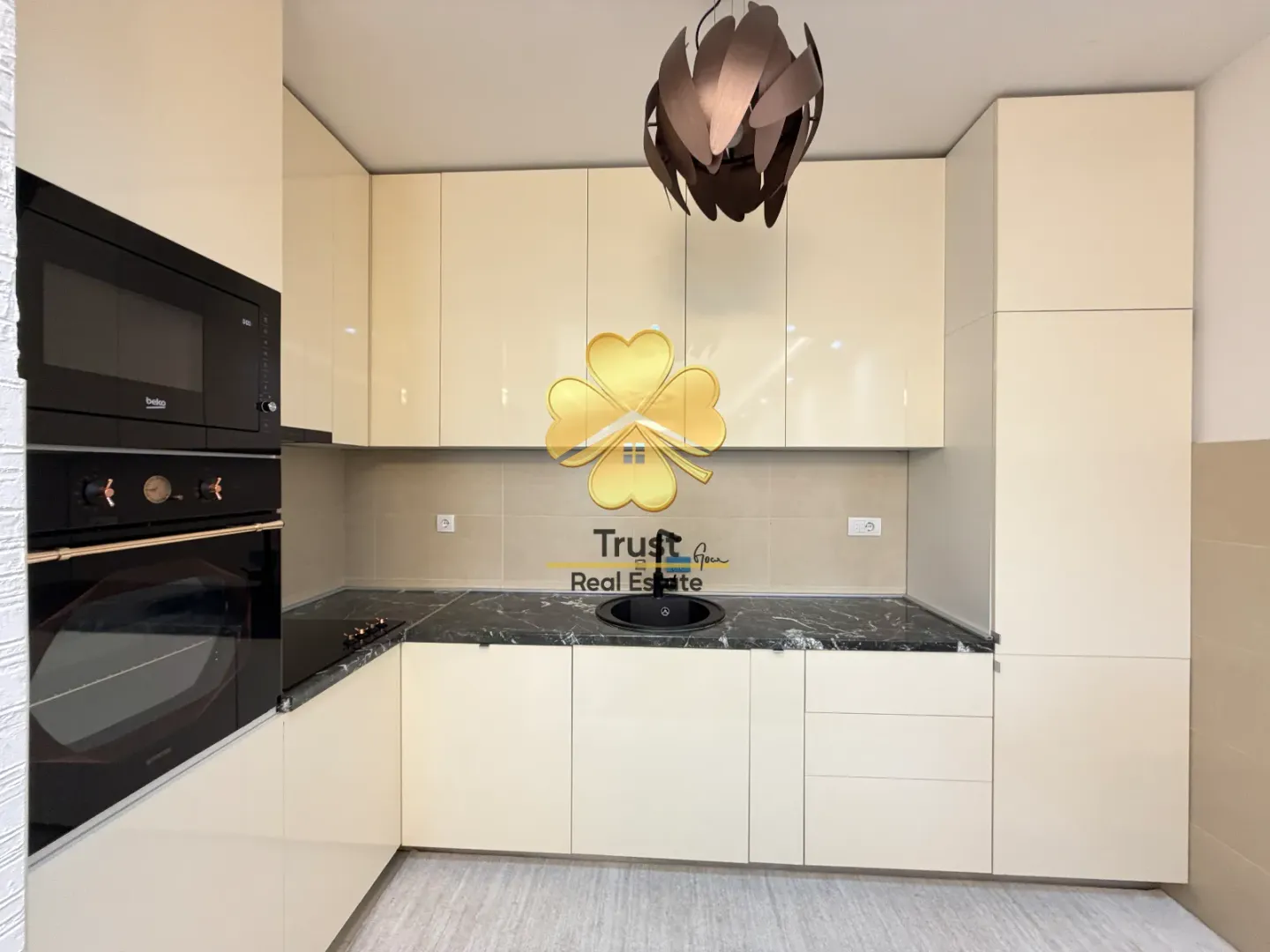 Modern kitchen with beige cabinets and dark countertop.