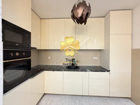 Modern kitchen with beige cabinets and dark countertop. - image 6