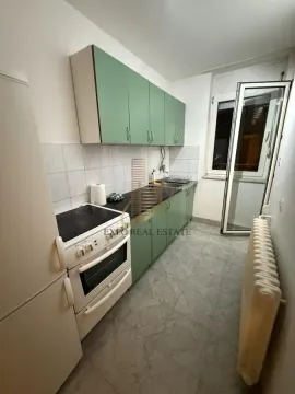 Manja kuhinja sa zelenim elementima i belim šporetom. - image 3