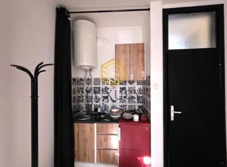 Small kitchen with a sink, refrigerator, and cabinetry.
