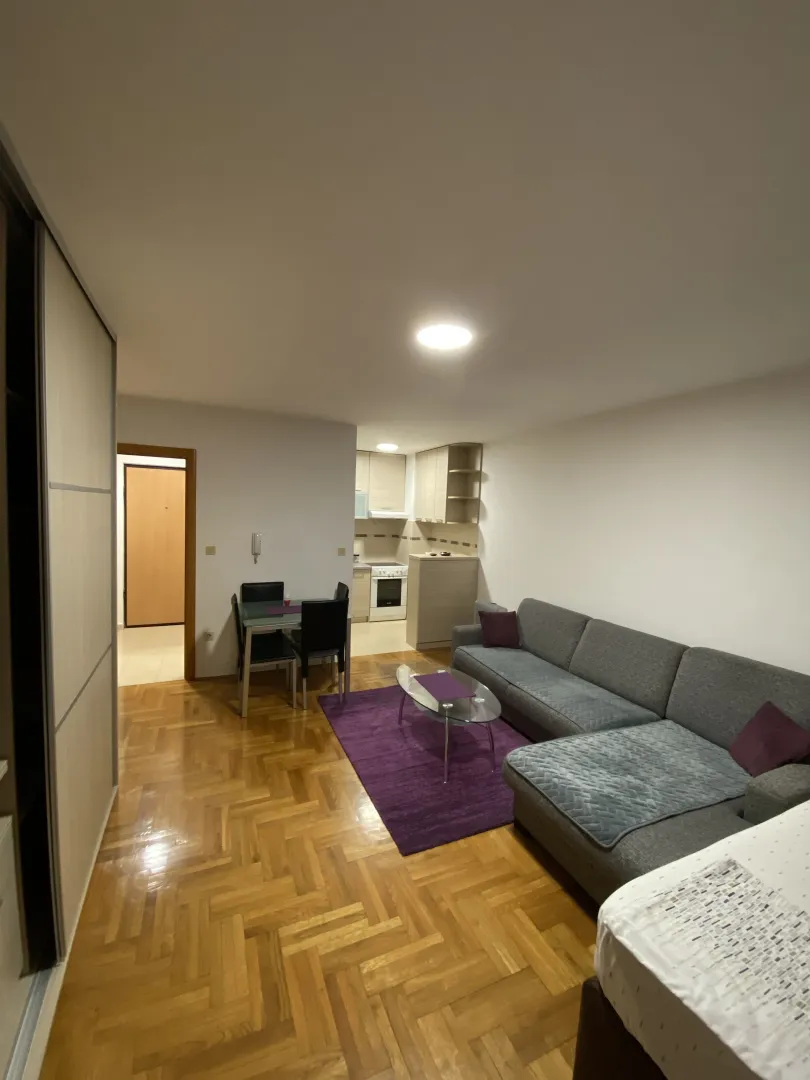 Bright living room with a sectional sofa and a dining area.