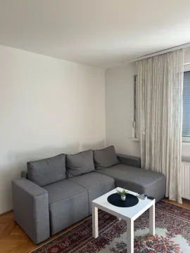 Corner sofa in the living room with a small coffee table and a window. - image 2