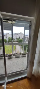 Pogled na balkonski prostor sa saksijama i okolne stambene zgrade. - image 11
