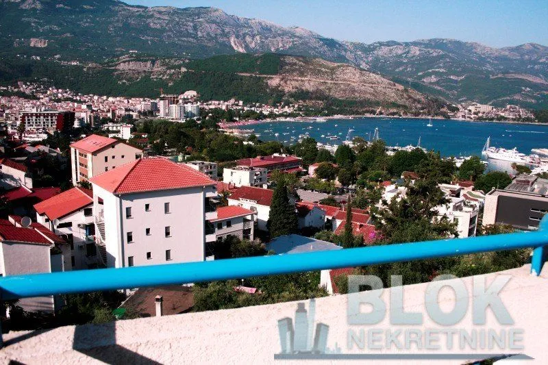 Pogled sa terase na grad, obalu i planine u pozadini.
