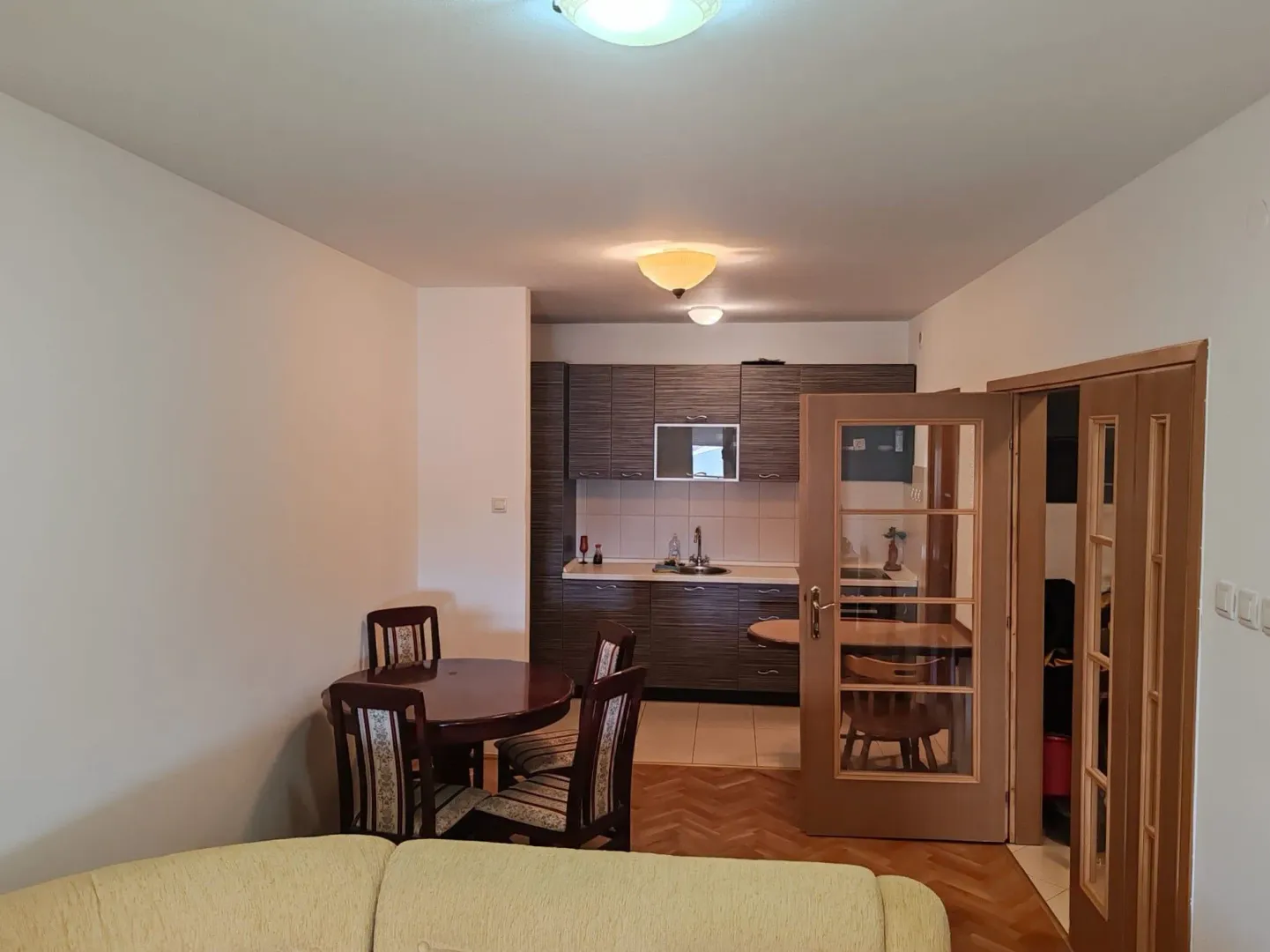 Living room with dining area and view of the kitchen.