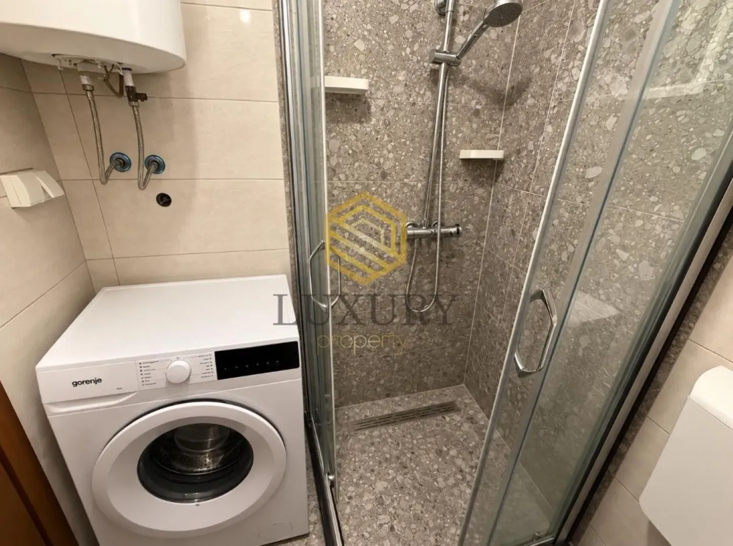 Small bathroom with a walk-in shower and a washing machine.
