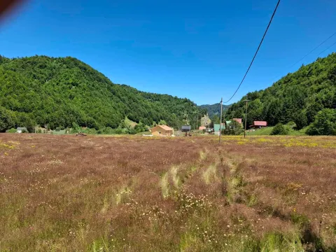 Pogled na prostranu livadu i okolne kuće u prirodi. - image 3