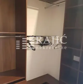 Prikaz ugradnog garderobera sa policama i vešalicama u sobi. - image 10