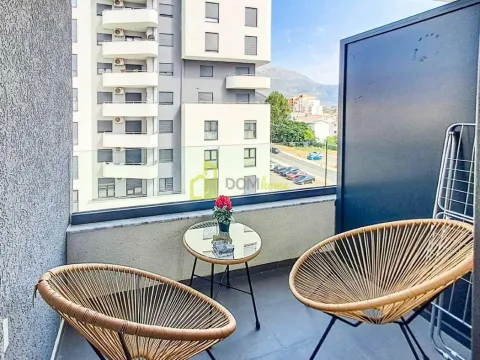 Furnished balcony with two chairs and a small table, overlooking the city. - image 10