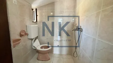 Smaller bathroom lined with ceramic tiles featuring a toilet and a shower fixture. - image 13