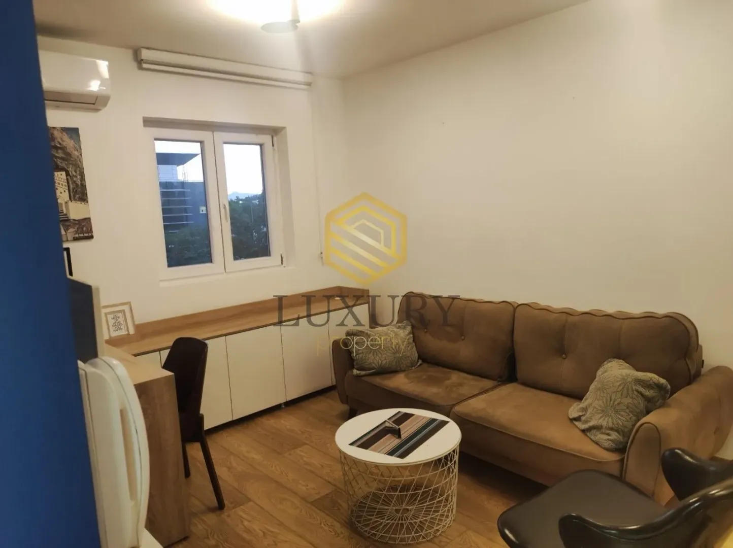 Dnevna soba sa garniturom, stočićem i radnim stolom.