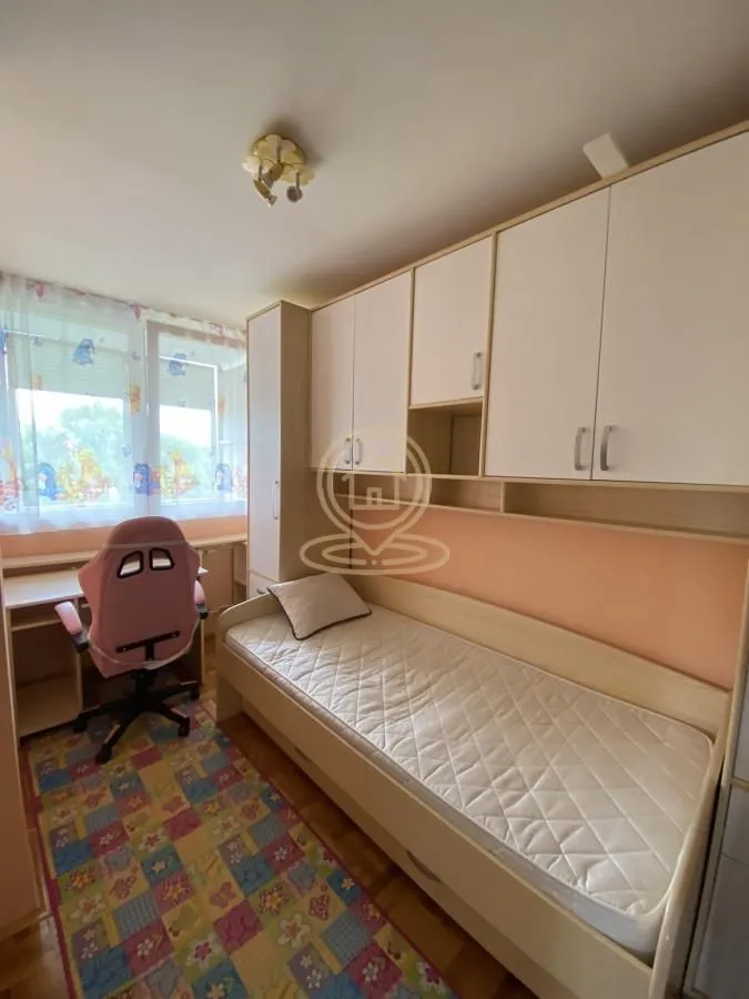 Dečja soba sa krevetom, garderoberom i radnim stolom.