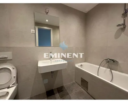 Modern bathroom with a bathtub, washbasin, and toilet tiled with ceramic tiles. - image 14