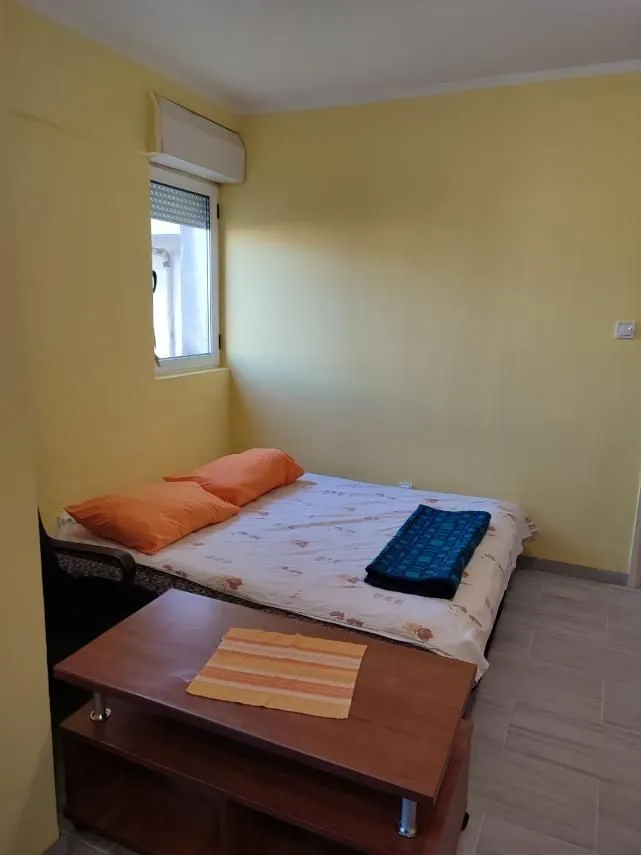 A simple bedroom with yellow walls and a double bed.