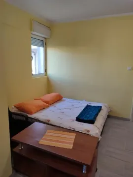 A simple bedroom with yellow walls and a double bed. - image 11