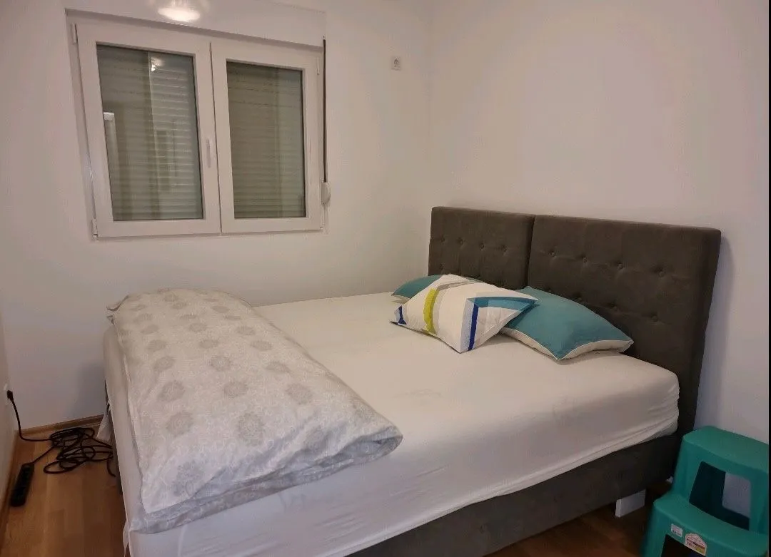 Furnished bedroom with a double bed and a window.
