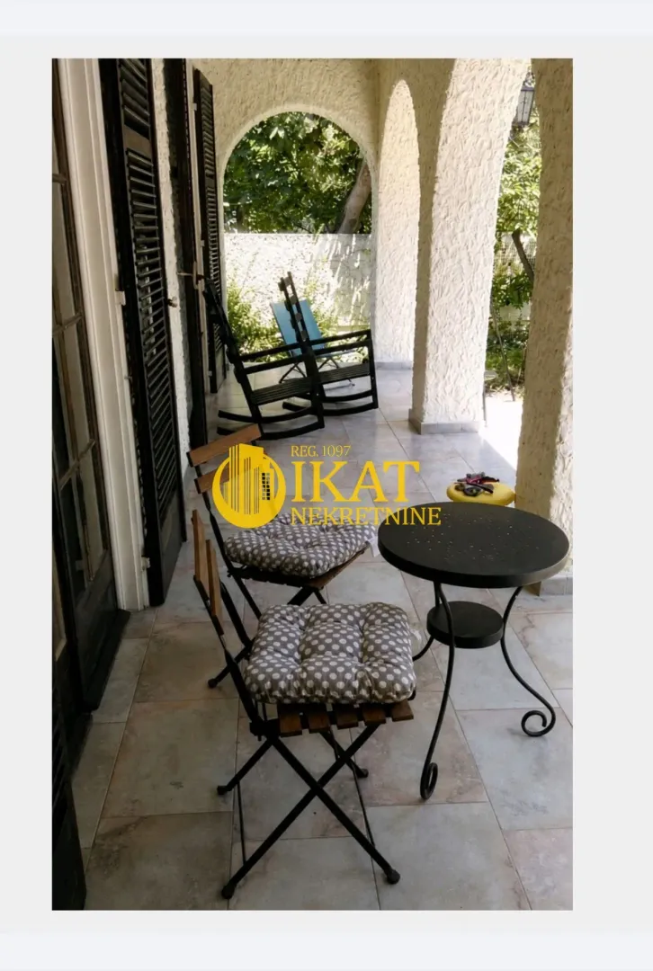 Covered terrace with seating furniture and a view of the courtyard.