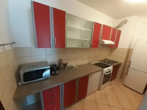 Kuhinja sa crveno-sivim kuhinjskim elementima i pratećom tehnikom. - image 3