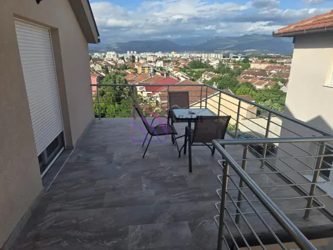 Spacious terrace with patio furniture and a city view. - image 6