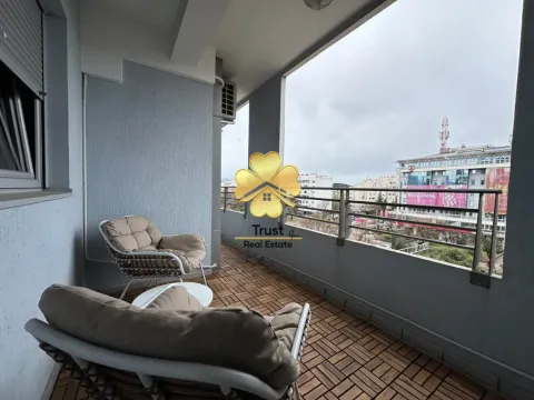 Spacious covered balcony with seating furniture and a city view. - image 6