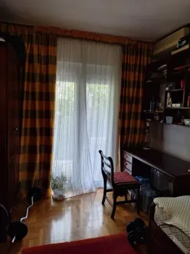 A bright room with a desk, wardrobe, and balcony access. - image 3