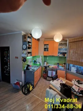 Kuhinja opremljena narandžastim elementima i trpezarijskim stolom. - image 6