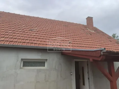 Pogled na spoljašnjost kuće sa krovom od crepa i ulaznim vratima. - image 10