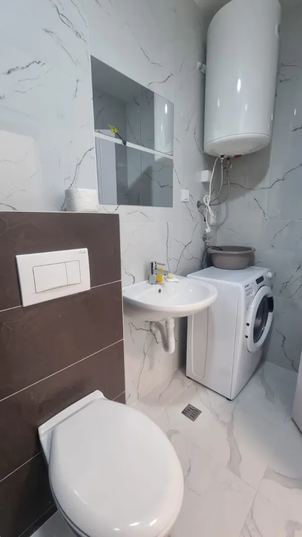 Modern bathroom equipped with sanitary fixtures and a washing machine.