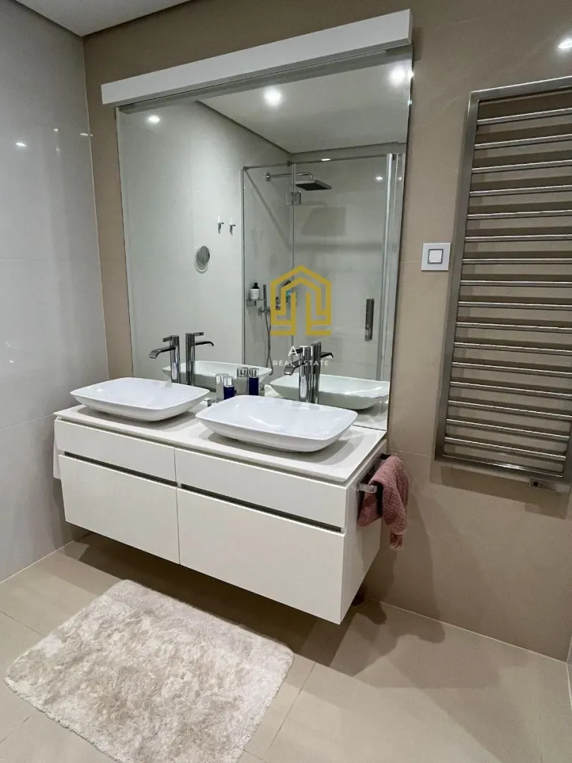 Modern bathroom with a double sink and a large mirror.