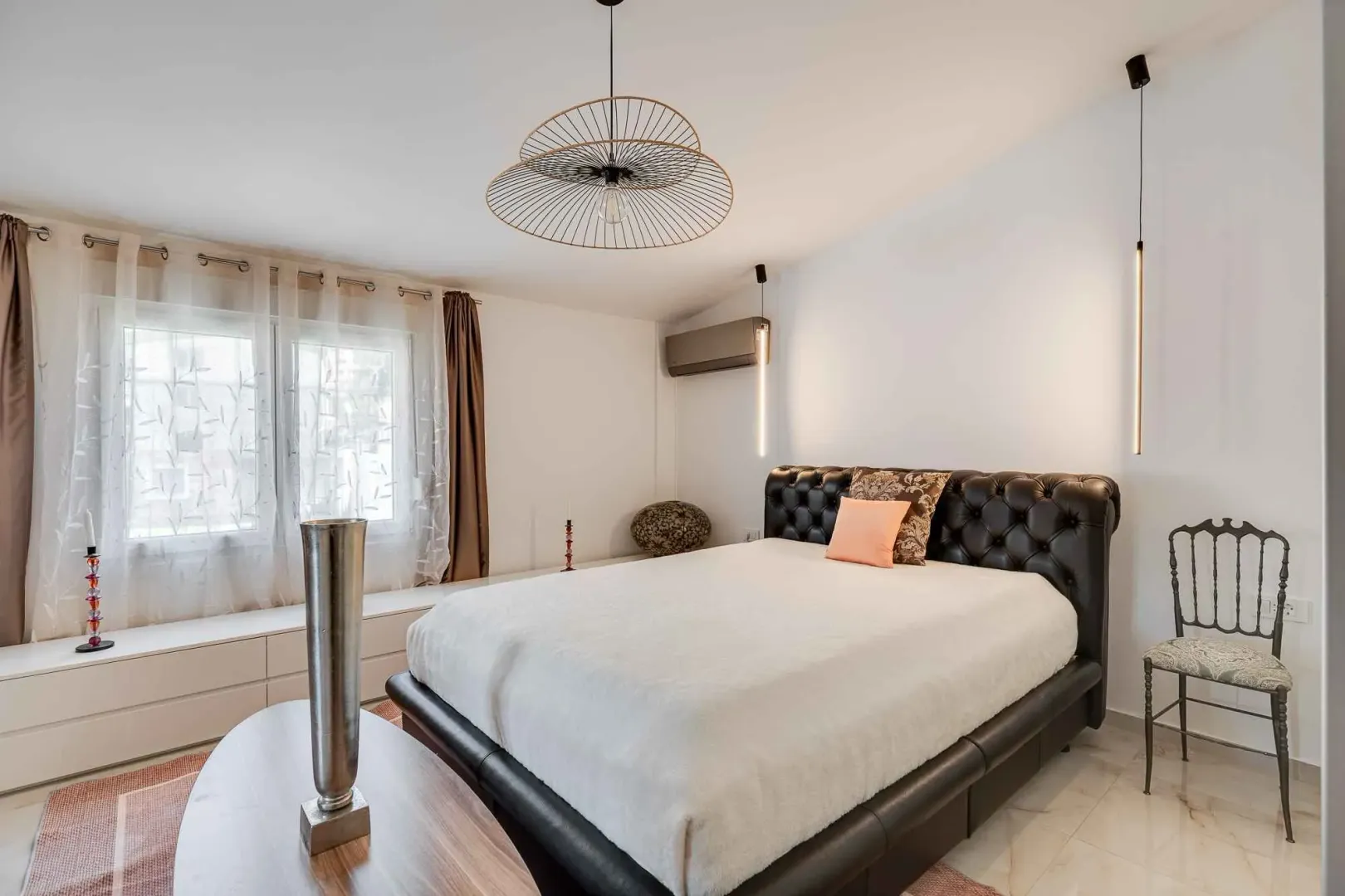 Prostrana spavaća soba sa velikim bračnim krevetom i modernim osvjetljenjem.