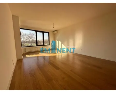 Empty room with wooden flooring and a large window. - image 2
