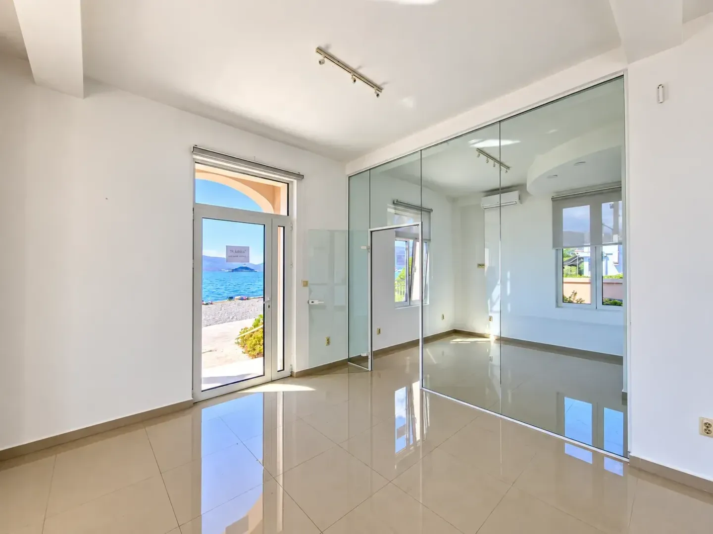 Empty bright room with a glass partition and a sea view.