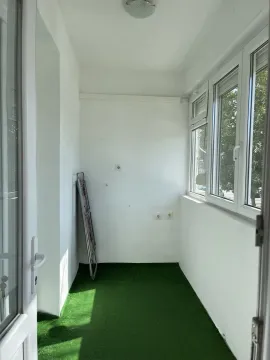 Enclosed balcony with artificial green turf on the floor and white walls. - image 9