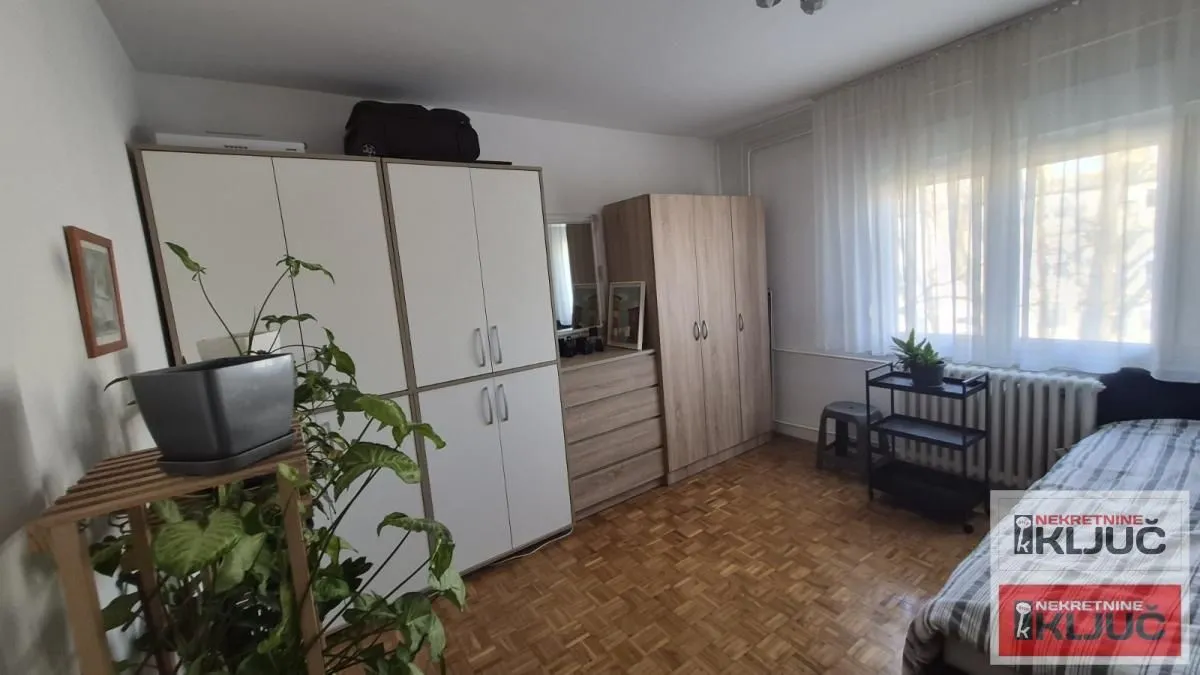 Nameštena spavaća soba sa garderoberima i krevetom.