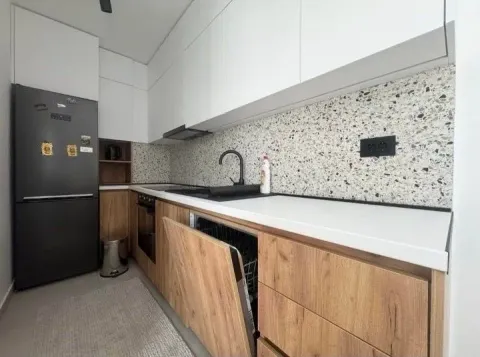 Modern kitchen with white and wooden cabinets and a black refrigerator. - image 7