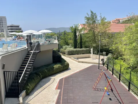 Exterior of the residential complex with a swimming pool and children's playground. - image 9