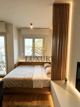 Modern bedroom with a double bed and wooden wall panels with LED lighting. - image 7