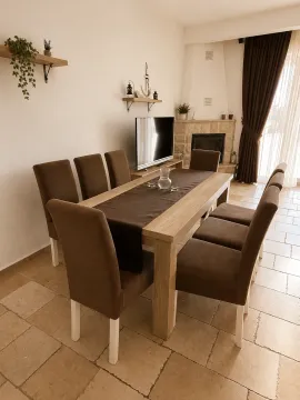 Trpezarija sa velikim stolom, stolicama i kaminom u uglu. - image 6