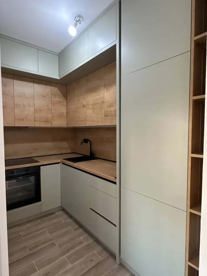 Modern kitchen with built-in cabinetry and wooden details.