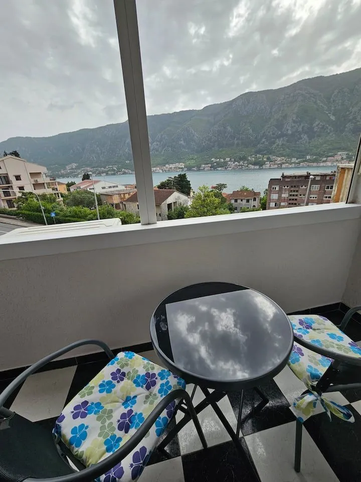 Covered balcony with seating furniture and sea view.