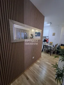 Dnevna soba sa drvenim zidnim panelom, ogledalom i pogledom na trpezariju. - image 5
