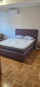 Spavaća soba sa bračnim krevetom i parketom na podu. - image 7