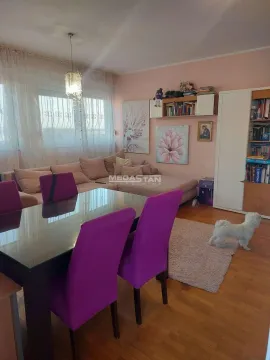 Living room with a sofa, dining table, and purple chairs. - image 6
